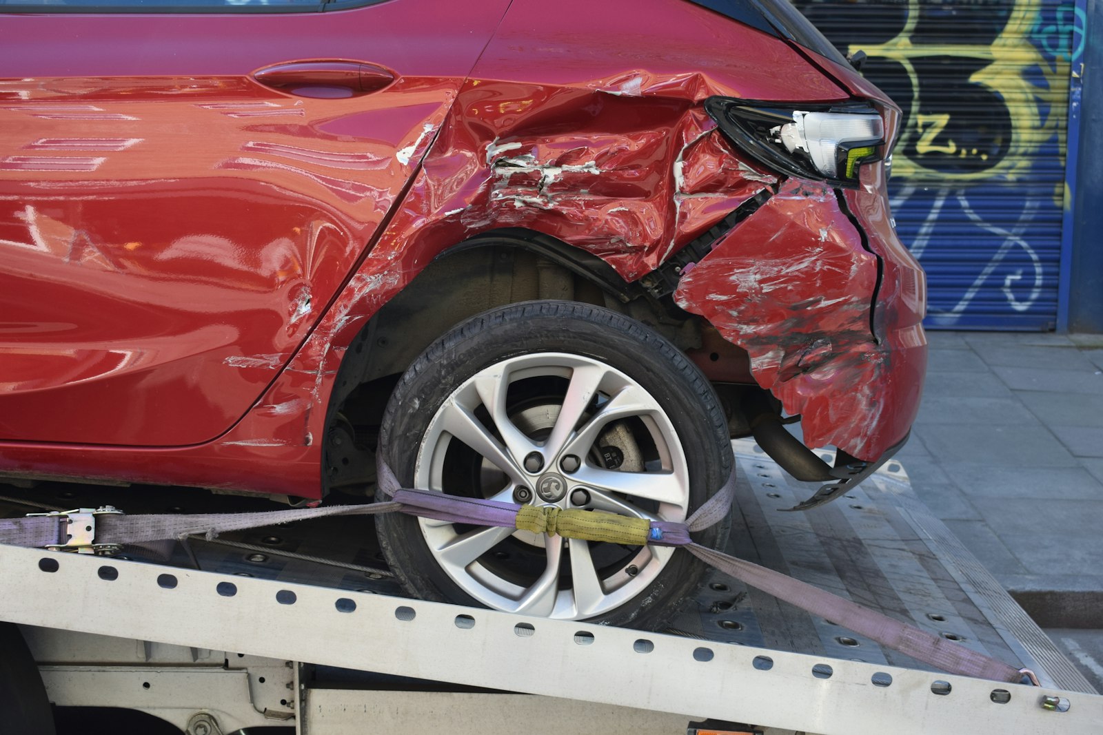 Damaged vehicle front end in a collision yard, representing professional auto body repair service